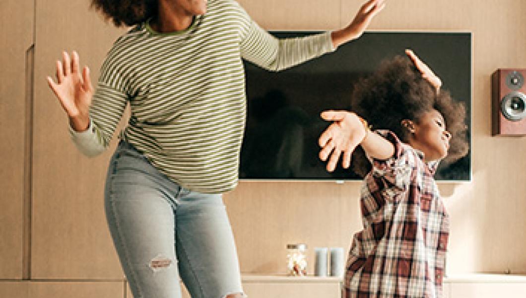 mother and daughter dancing in living room