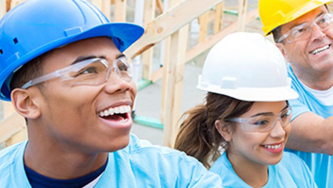 group of three people building a house