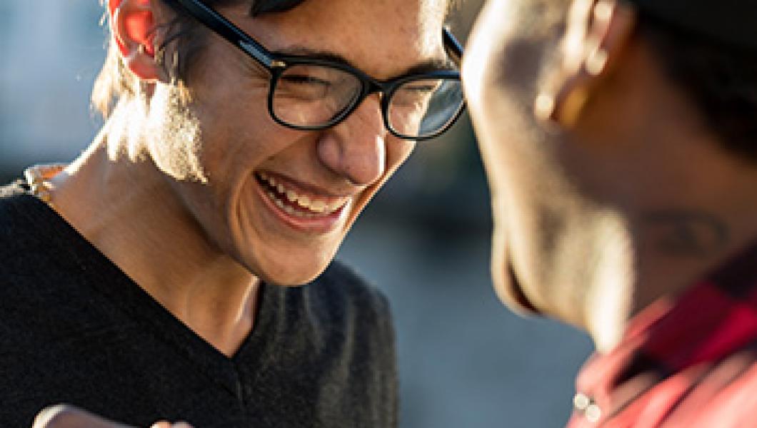 young man smiling embracing a friend