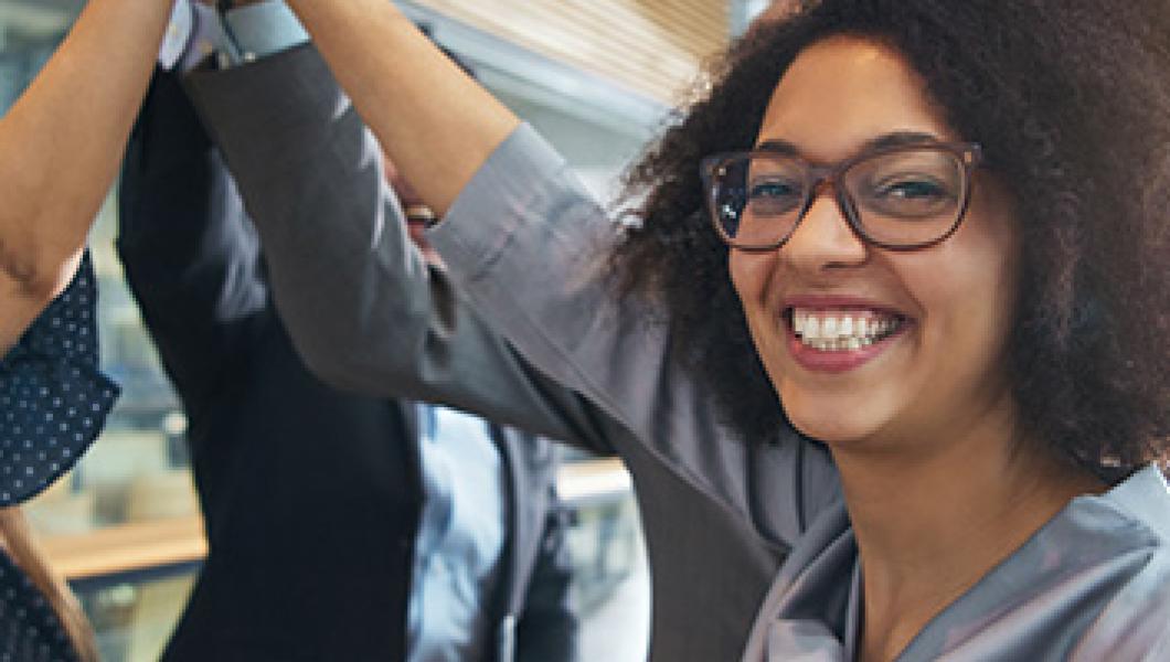 smiling woman high-fiving coworkers