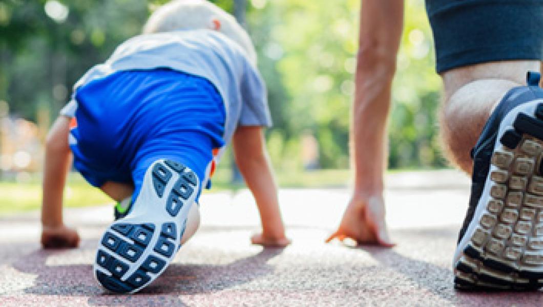 young boy lining up to race his father