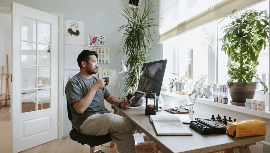 man with coffee at home office