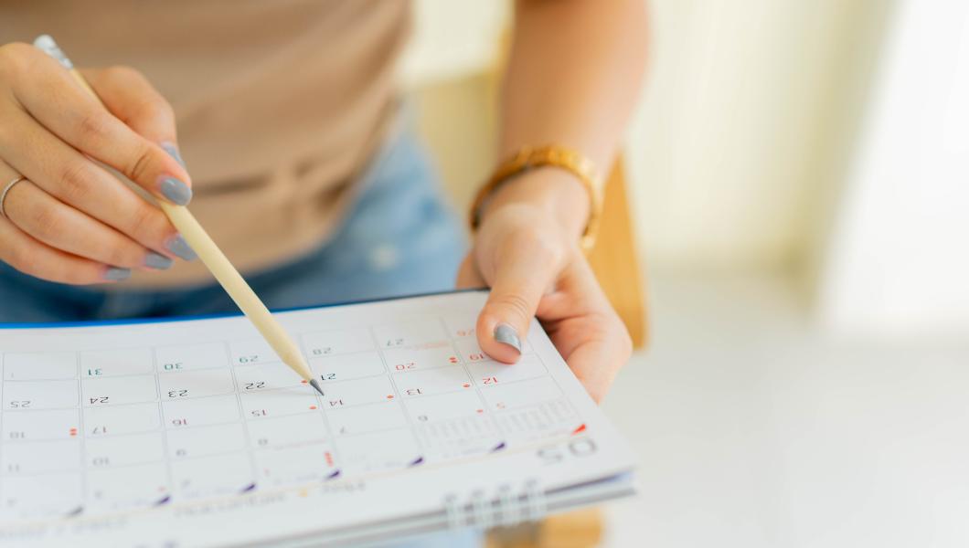 woman writing on printed calendar