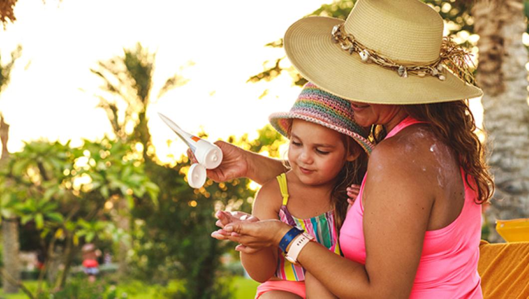 mother and daughter applying sunscreen