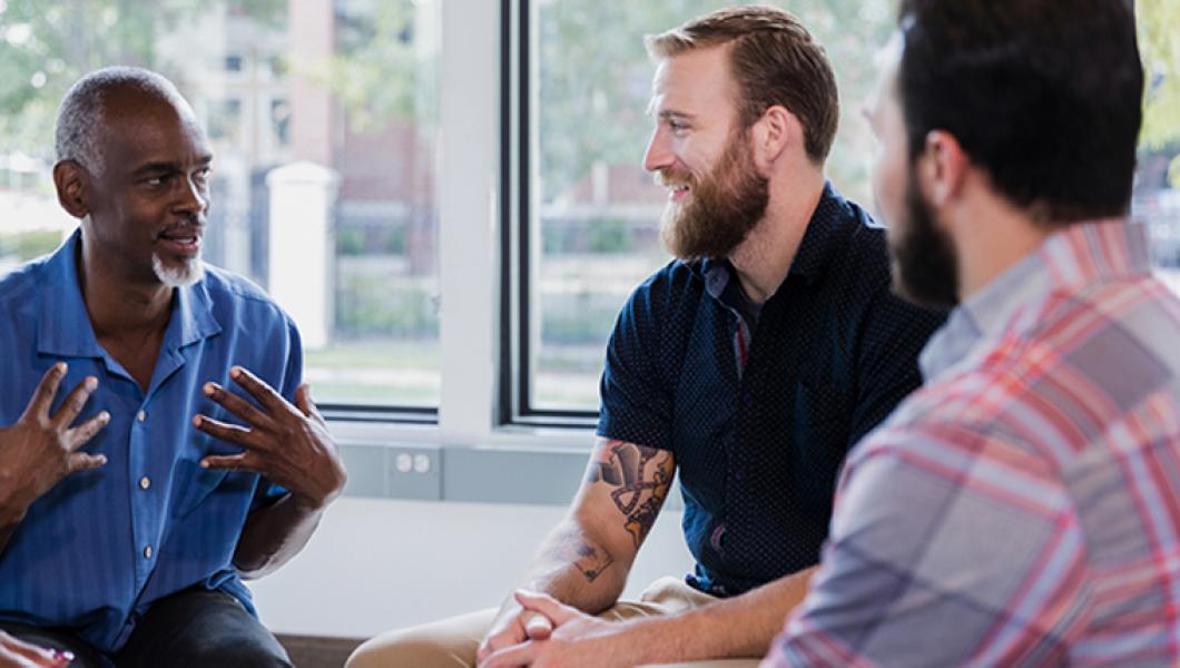 Three men talking at meeting