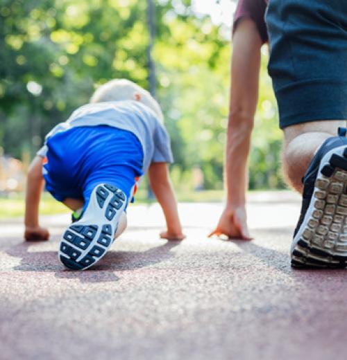 young boy lining up to race his father