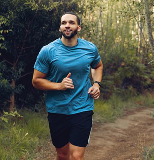 Man jogging down wooded path