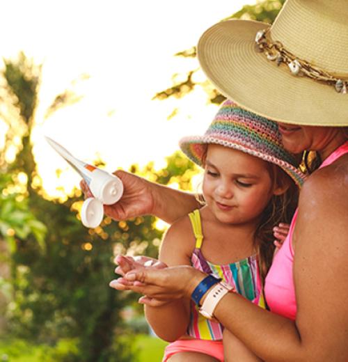 mother and daughter applying sunscreen