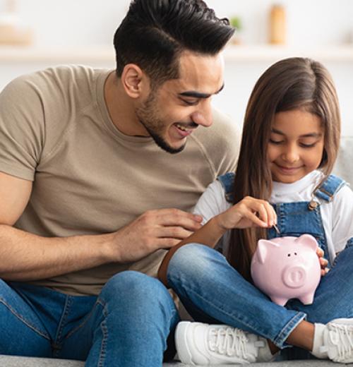 father teaching daughter to save money